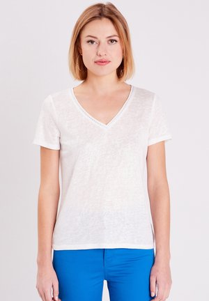 Weißes T-Shirt mit kurzen Ärmeln und V-Ausschnitt aus leichtem Stoff mit subtiler Textur. Auffällige Details sind die dekorativen Nähte am Ausschnitt.