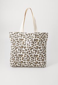 Leopard-print tote bag in beige, featuring brown and black spots. Canvas material with two sturdy cream-colored handles.