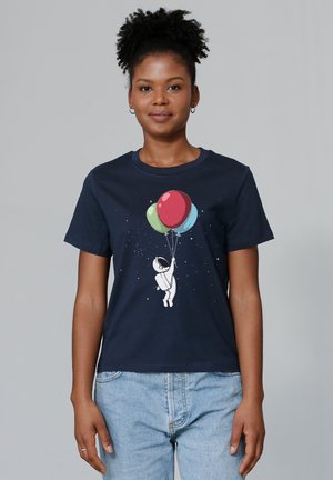Marineblauw T-shirt van een katoenmix met een illustratie van een astronaut die kleurrijke ballonnen vasthoudt tegen een sterrenachtige achtergrond.