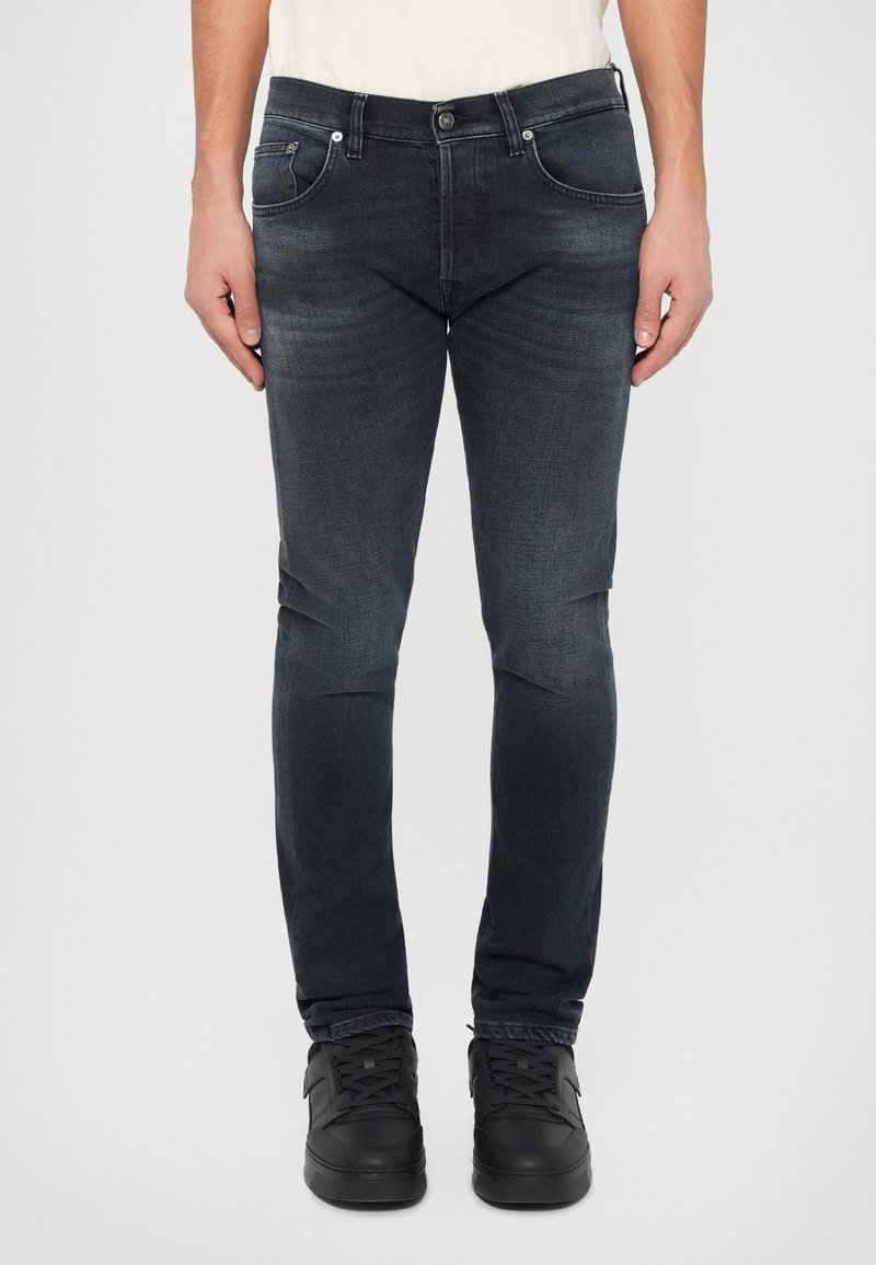 Mörkblå denimjeans med slim fit, som har fem fickor, metallbeslag och subtila blekningar. I kombination med svarta sneakers.