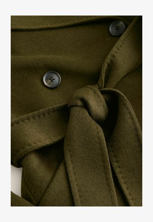 Olive green fabric wrap with a tied knot, featuring two dark buttons. Soft texture with stitched accents along the edges.
