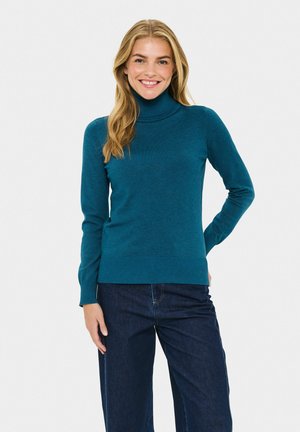 Taschenfarbener Rollkragenpullover aus weichem Strickmaterial mit langen Ärmeln und figurnaher Saum, getragen mit dunklen Jeans. Minimalistisches Design, keine Muster.