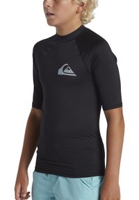 T-shirt de rash en noir à manches courtes, fabriqué dans un matériau extensible, avec un design de logo gris sur la poitrine et des coutures plates pour le confort.