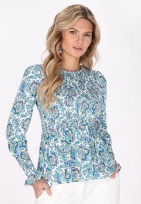 Blusa a manica lunga in tessuto leggero con un motivo floreale paisley blu, verde e bianco, dettagli smock e polsini fru-fru.