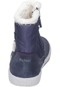 Marineblauwe enkelboot met een gestructureerde suede afwerking, een met bont gevoerde kraag en een zijrits. Voorzien van een rubberen zool met een versterkte hiel.