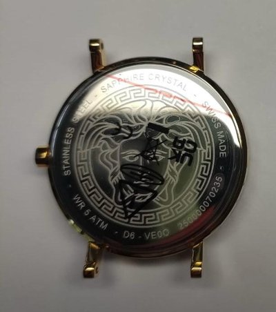Cassa dell'orologio in acciaio inossidabile con superficie lucidata, design di un leone inciso e motivo a chiave greca. Contrassegnata con "Cristallo Zaffiro" e "Made in Switzerland."