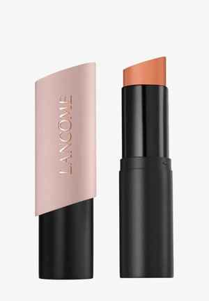 Rouge à lèvres Lancome avec un bouchon beige montrant le nom de la marque et une teinte corail douce exposée dans un tube noir.