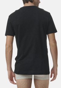 Black cotton t-shirt with a round neck, short sleeves, and straight hem. Visible stitching details on the shoulder seams.
