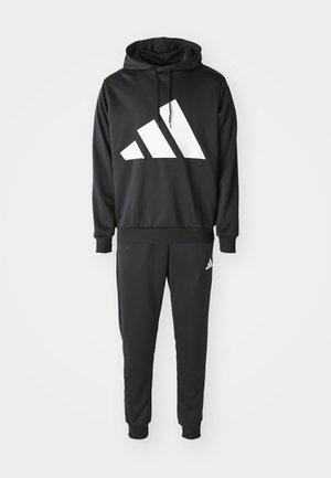 Ensemble sweat à capuche noir et joggers en tissu lisse. Présente un grand logo blanc sur la poitrine et un logo plus petit sur la jambe du pantalon.