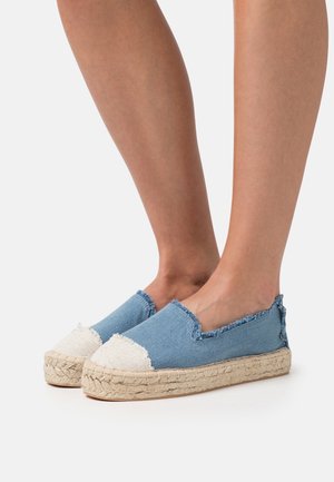 Denim espadriller med en flosset kant, lys blå krop, hvid kanvas tåhætte og vævet jute sål. Flad slip-on design.