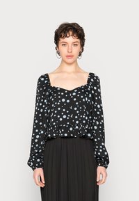 Blusa preta com bolinhas azul claro, decote quadrado, mangas franzidas e bainha peplum. Possui fecho frontal por botões.