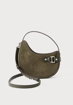 Sac à main en daim vert olive en forme de croissant, avec une sangle en cuir réglable et un détail de boucle en argent sur le devant, sur fond blanc.