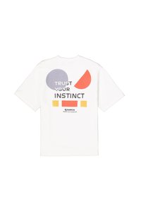 Camiseta blanca de algodón con un diseño gráfico geométrico en púrpura, naranja y amarillo, con el texto "CONFÍA EN TU INSTINTO" mostrado de manera destacada.