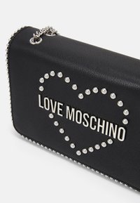 Borsa a tracolla in pelle nera con un'incrostazione a forma di cuore in perle e la scritta "LOVE MOSCHINO" in lettere argentate, dotata di tracolla a catena.