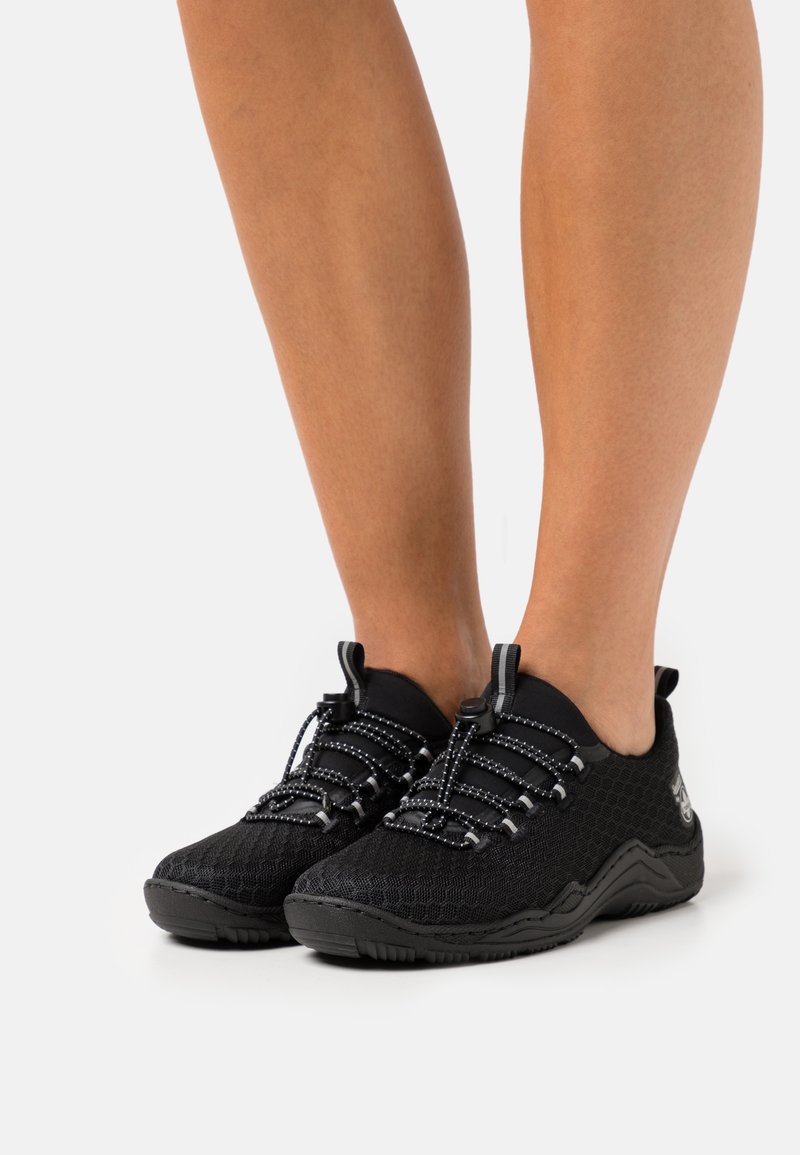 Black athletic shoes made of mesh material with a textured surface, featuring elastic laces and a molded rubber outsole.
