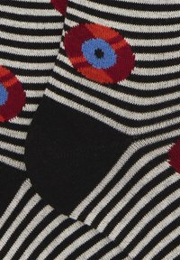 Schwarz-weiße gestreifte Socken mit roten und blauen Blumenmustern. Weiche Stricktextur mit kontrastierenden schwarzen Fersen- und Zehenbereichen.