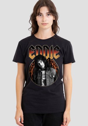 Woman wearing black t-shirt with "EDDIE" text and circular graphic of person in denim jacket with flames in background.