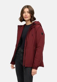 Maroon insulated jacket with a hood, full zipper, and adjustable drawstrings. Features side pockets and a logo patch on the sleeve.