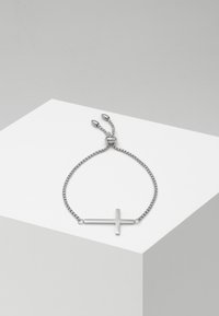 Sølvkjede armbånd med et minimalistisk korsvedheng; glatt tekstur, justerbar lengde med glidende perle-lukkning.