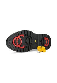 Suola di stivale in gomma nera con scanalature profonde, accenti circolari rossi e un'etichetta di sicurezza gialla. Hardware notevole comprende borchie in metallo.