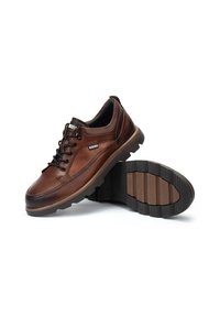 Zapatos de cuero marrón con punta redonda, acentos texturizados y cordones negros. Suela de goma con dibujo para mayor tracción. Vista frontal mostrada.