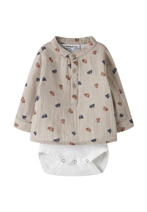 Béžové detské overal na dlhý rukáv s gombíkovou légou a vzorom modrých a hnedých medvedíkových tvárí, s pripojeným bielym spodným dielom s patentkami.