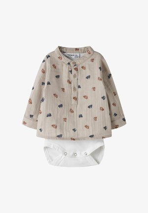 Beżowy niemowlęcy kombinezon z długim rękawem, zapinany na guziki z przodu, z wzorem niebieskich i brązowych twarzy misiów pluszowych, dołączone białe body zapinane na napy na dole.