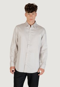 Camicia a maniche lunghe a righe grigio chiaro realizzata in tessuto morbido, con colletto classico, chiusura frontale con bottoni e vestibilità sagomata.
