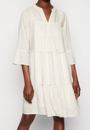 Robe beige clair à rayures verticales blanches, aux manches trois-quarts, avec un ourlet volanté et un col en V, fabriquée en tissu doux et texturé.