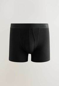 Schwarze Boxershorts aus dehnbarem Material mit glatter Textur. Mit einem schwarzen elastischen Bund mit dezentem Branding und einer taillierten Passform.