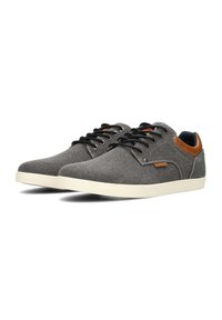 Graue Canvas-Sneaker mit einer glatten Textur, weißer Gummisohle, schwarzen Schnürsenkeln und braunen Lederelementen an Ferse und Zunge.