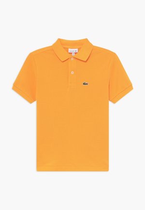 Pomarańczowa koszulka polo z bawełny, z klasycznym kołnierzem, plisą na dwa guziki oraz wyszywanym logo Lacoste na lewej piersi.