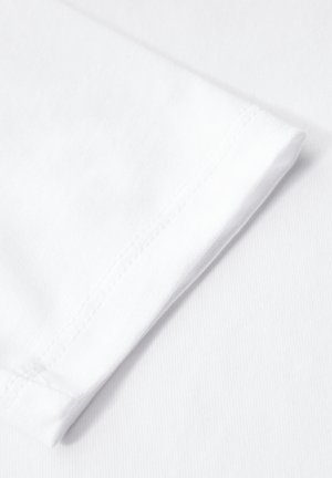Biała bawełniana tkanina z podwinięciem rękawa. Tekstura jest gładka z delikatnym połyskiem. Szw można dostrzec wzdłuż krawędzi.