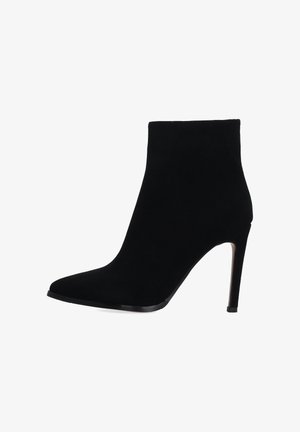 Černá semišová kotníková bota s špičatou špičkou a vysokým jehlovým podpatkem. Hladká textura s elegantní siluetou, bez viditelného hardwaru nebo ozdob.