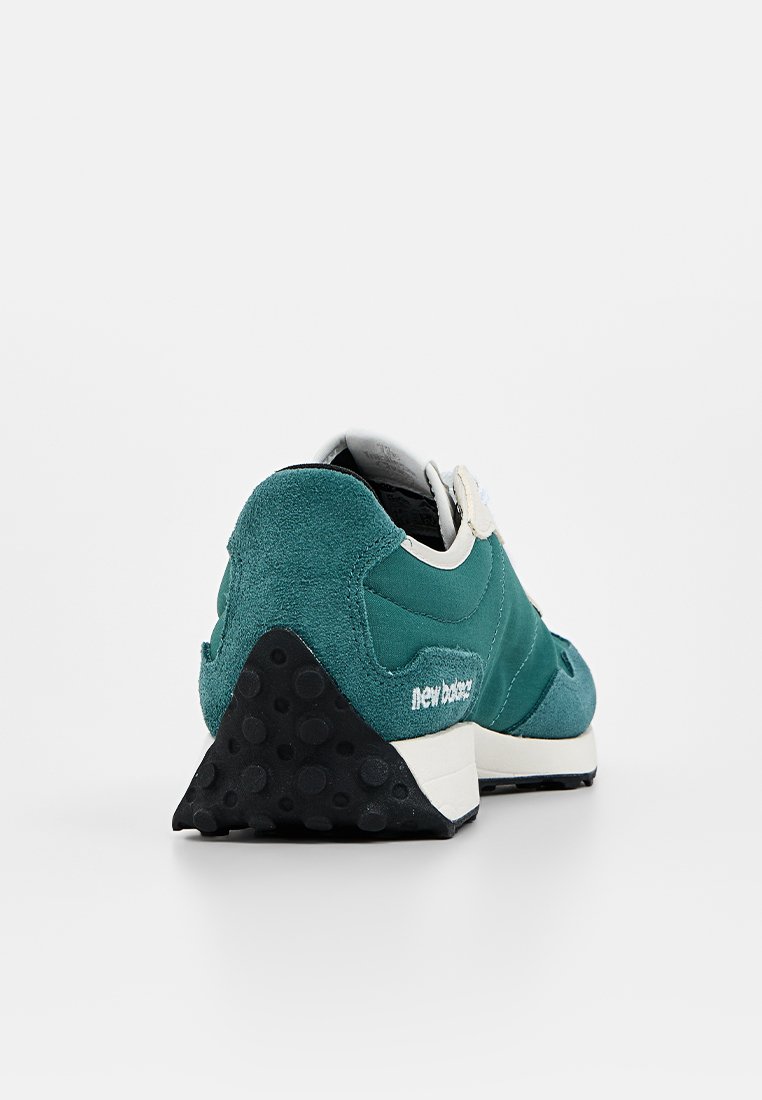 Baskets teal en mélange de matériaux en daim et en mesh, avec un logo blanc et une semelle en caoutchouc noir texturé dotée d'un design de talon triangulaire.