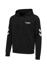 Zwarte zip-up hoodie gemaakt van zachte stof. Heeft een kangoeroezak, een capuchon met trekkoord, en witte logo- en chevronaccenten op de mouwen.