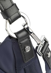 Cinturino in pelle nera attaccato a un anello metallico rotondo, con un gancio in argento, una sezione in tessuto blu navy e un dettaglio con un pulsante logo in argento.