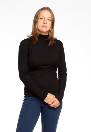 Maglia nera a maniche lunghe con collo alto, realizzata in tessuto liscio, con una forma aderente e maniche lunghe fino ai polsi, abbinata a jeans blu.