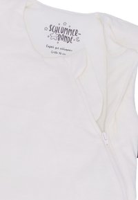 Weißer Babyschlafsack mit einem Reißverschluss. Weicher Stoff, runder Halsausschnitt und Etikett mit Text und Sternen, die oben aufgedruckt sind. Größe 70 cm.