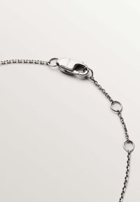 Pulsera de cadena de plata con eslabones ovalados entrelazados, cierre de langosta y pequeños acentos circulares a lo largo del diseño.