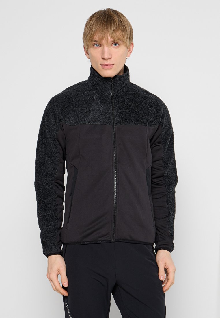 Giacca di pile con colletto alto, colori nero e carboncino, zip frontale e tessuto testurizzato sulle spalle e sulle maniche.