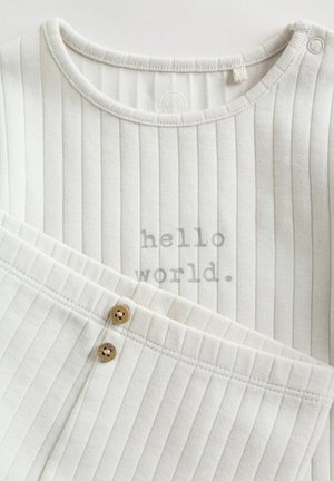 Weißes, geripptes Baumwolloutfit mit rundem Ausschnitt, versehen mit dem Text "hello world" in Grau und zwei Holzknöpfen an der Hose.