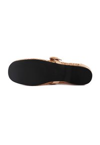 Woven tan leather sandal with a wide strap, black rubber sole, and adjustable buckle, featuring a textured finish on the upper.