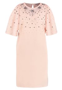 Svetle růžové šaty po kolena s krátkými rukávy, kulatým výstřihem a stříbrnými kamennými ozdobami na horní části hrudníku a ramenou.