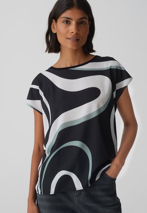 Haut noir à manches courtes avec des motifs ondulés abstraits en blanc et teal. Tissu doux et léger ; décolleté rond ; coupe décontractée.