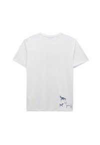 Camiseta de algodón blanca con mangas cortas, cuello redondo, que presenta un gráfico azul de tres perros cerca de la parte inferior izquierda. Textura suave.