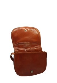 Sac en cuir marron avec une texture lisse, fermeture à rabat et bouton pression. L'intérieur est non doublé, mettant en valeur un design minimaliste.