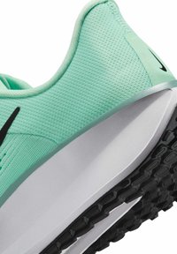 Muntgroene sportschoen met bovenwerk van mesh, zwarte accenten, een witte middenzool en een gestructureerde rubberen zool. Kenmerkt een slank ontwerp en vloeiende lijnen.