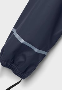 N�ámornícky modrá nepremokavá bunda s elastickými manžetami, s reflexnou pruhou na rukáve a sťahovacou šnúrkou na spodnom leme.