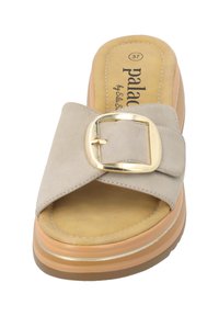 Sándal beige con una amplia correa de ante que presenta una hebilla dorada. Suela de plataforma gruesa con un acento en tostado y dorado. Plantilla suave y texturizada.